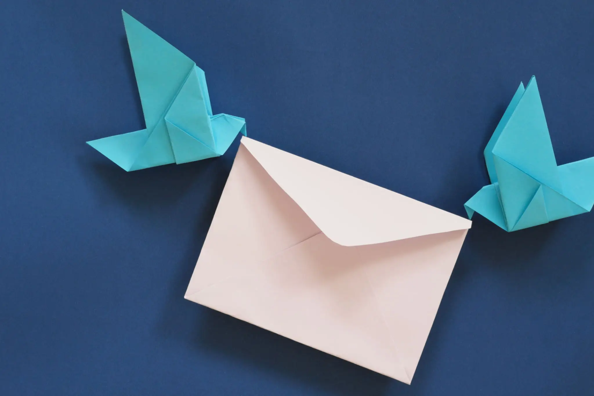 An envelope with origami birds on a blue background.
