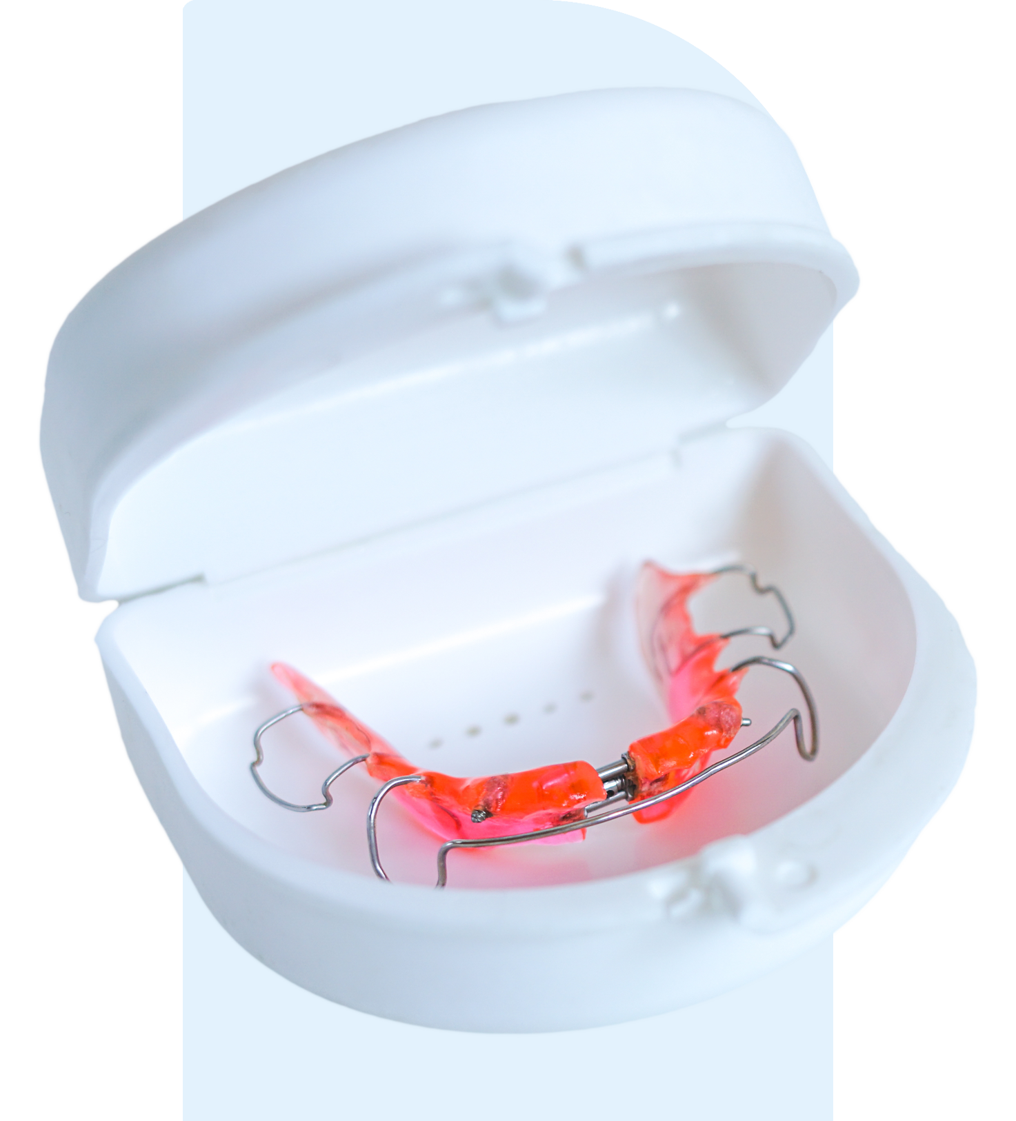 A dental retainer in a protective white case.